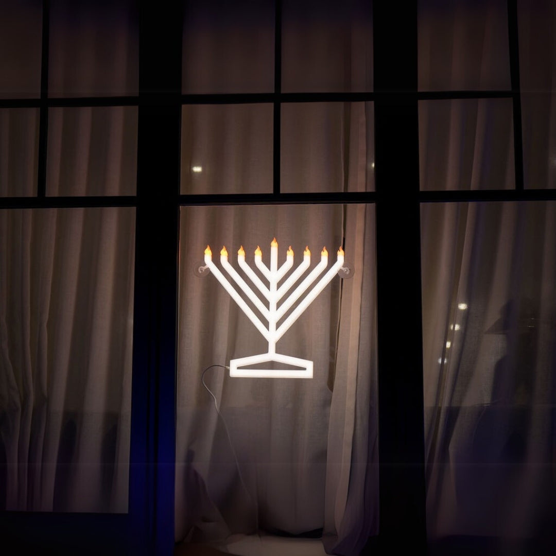 View of the Illumin8 electric Menorah from outside the window, highlighting its visibility on modern home