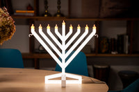 Modern Chanukah decor on table featuring the Illumin8 Menorah as an eye-catching light up centerpiece